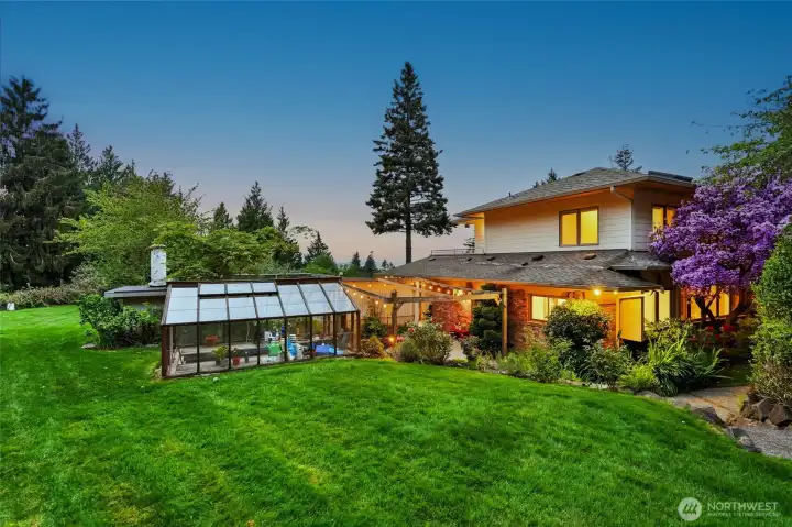 The side yard offers a fun patio area, a greenhouse and a swimming pool.