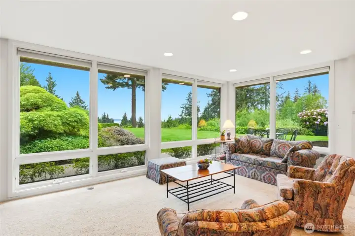 The family room enjoys looks at the greenery of the yard and blue of Puget Sound.