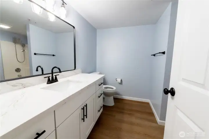 Updated full bathroom featuring a modern vanity, quartz countertop and refreshed fixtures