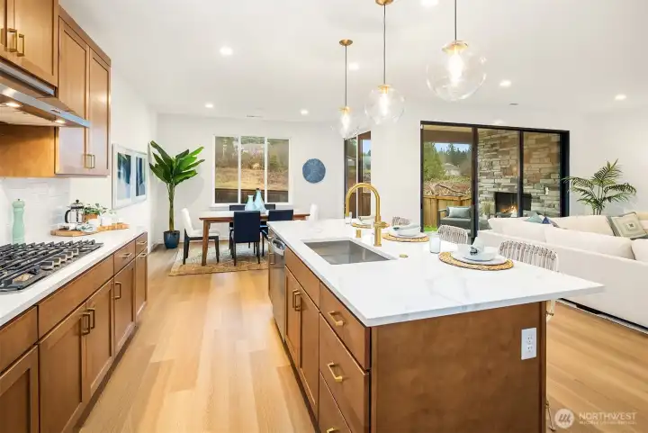 The kitchen is a stunning blend of soft toffee-colored cabinetry, perfectly complemented by white picket tile backsplash, modern brass cabinet hardware, and Ripieno quartz countertops featuring a crisp white background and subtle taupe veining