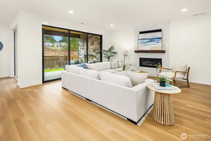 Modern linear gas fireplace with sparkling glass fire stones in great room with full height wall tile is sure to make a statement