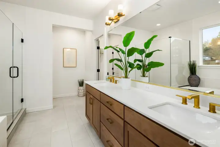 Beautiful primary suite features a large walk-in closet and a spa-inspired bathroom with a large soaking tub and walk-in shower with a frameless glass door enclosure