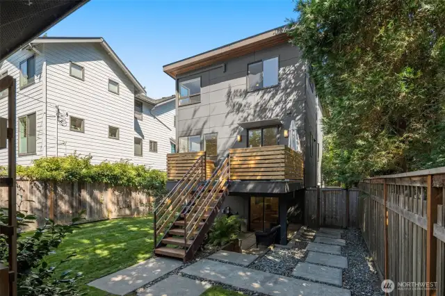 View of the back side of the home, showcasing outdoor gathering spaces