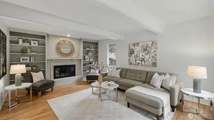 Spacious family room is highlighted with large windows, built-in shelving, and floor-to-ceiling brick gas fireplace.