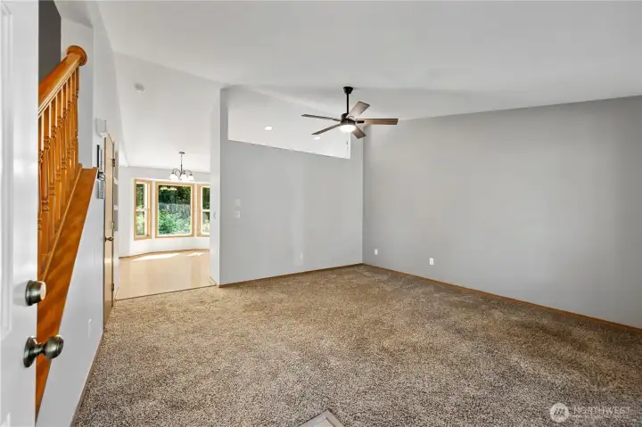 Bright and inviting living room featuring vaulted ceilings.