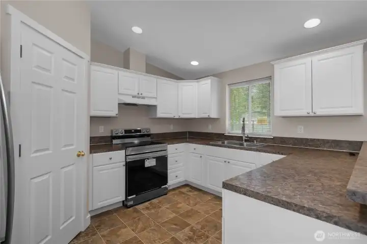 Clean kitchen with white cabinets, new Refrigerator and Range/Oven, tile flooring, recessed lighting, and ample counter space. Clean kitchen with white cabinets, new Refrigerator and Range/Oven, tile flooring, recessed lighting, and ample counter space.