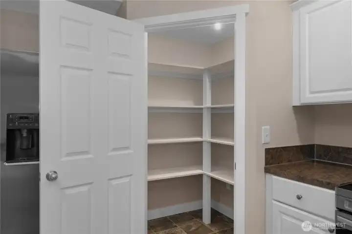 Walk-in pantry with built-in shelving located just off the kitchen for convenient storage. Walk-in pantry with built-in shelving located just off the kitchen for convenient storage.