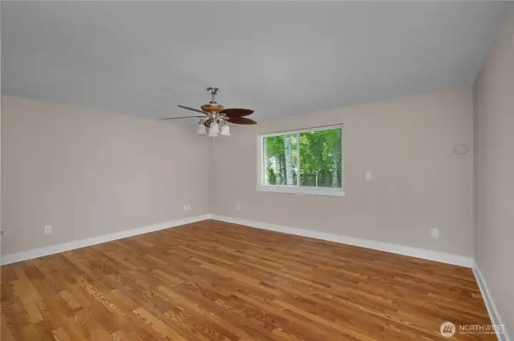 Spacious primary bedroom with updated flooring, fresh paint, large window, and ceiling fan. Spacious primary bedroom with updated flooring, fresh paint, large window, and ceiling fan.