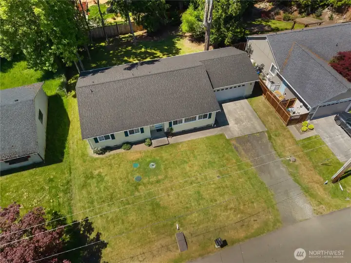 Overhead aerial view of the rambler, attached garage, driveway, front yard, and backyard setting. Overhead aerial view of the rambler, attached garage, driveway, front yard, and backyard setting.