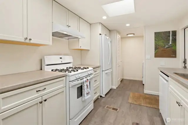 Remodeled kitchen with a gas range, laminate floors, new soft close and slide out cabinets and skylight.