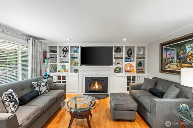 The family room has custom built ins that surround the gas fireplace.