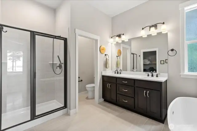 Primary bath features free standing tub, heated towel rack and walk in closet (opposite the vanity).