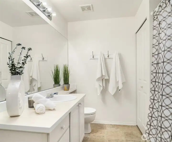 The main bath features ample counter and cabinet space for storage, a luxurious soaking tub for relaxation, and a convenient linen closet for added organization.