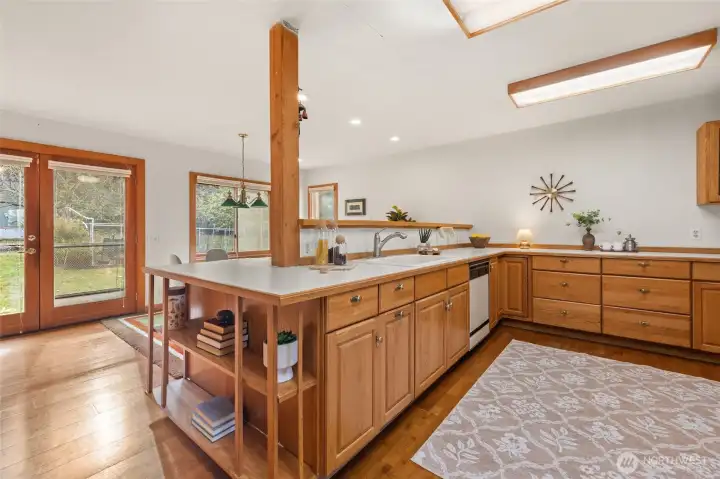 The spacious kitchen and family room overlook a private backyard with mature landscaping and fruit trees.