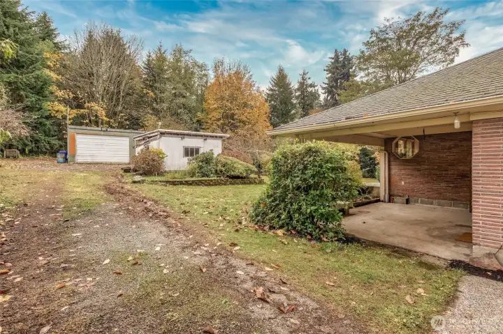 The small white outbuilding was used as an outdoor kitchen. The larger shop is beyond.