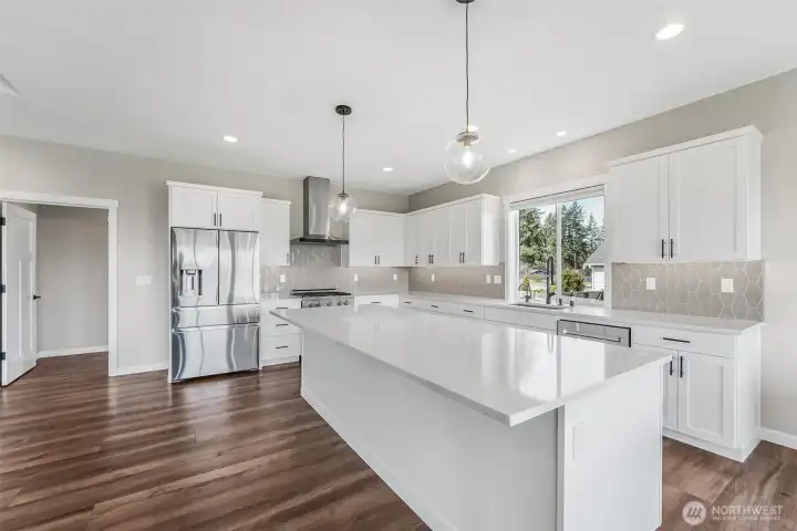 The open concept kitchen with eating space, quartz countertops and stainless steel appliances make this kitchen an entertainer’s dream.