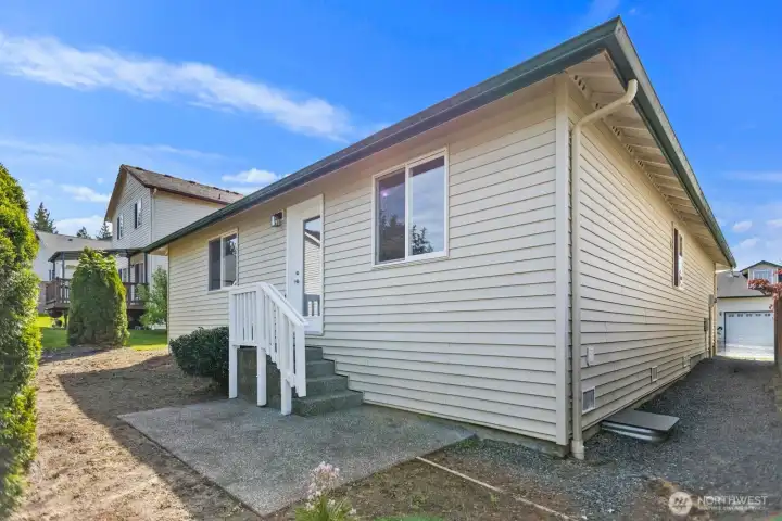 Back of the home with a cement patio.
