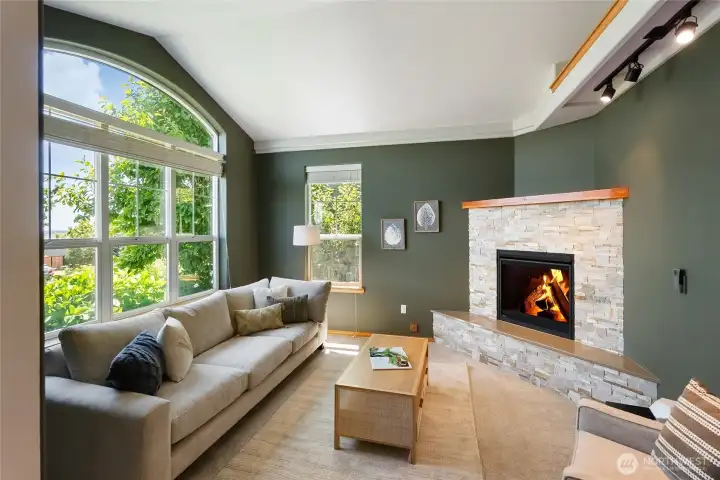 Front living room with large south facing windows, expansive views, and a cozy fireplace