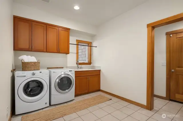 The spacious laundry room on the main level with nice storage and and handy sink.