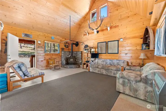 Great room is wrapped in cedar wood ceiling to floor. Free standing Wood stove on rock hearth assures all a warm comfortable stay.