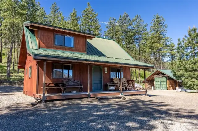 Cabin covered porch has graveled area around all building for unencumbered access with tons of parking. Wood shed and secure container offer extra storage for your gear. Cell reception good.