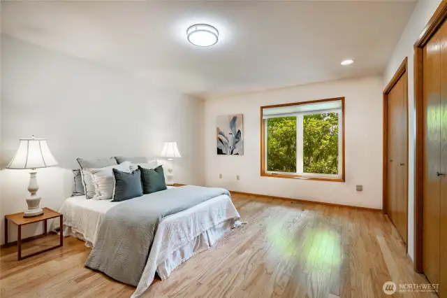 Primary bedroom, hardwood floors, double closets, window to back yard
