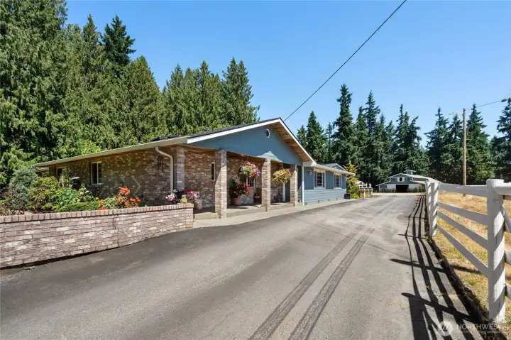 Driveway lined with fencing and trees, leading to the heart of the property.