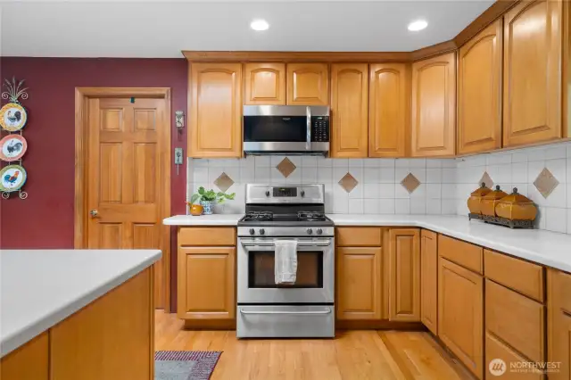 Modern kitchen features gas range, oven, and abundant cabinetry.