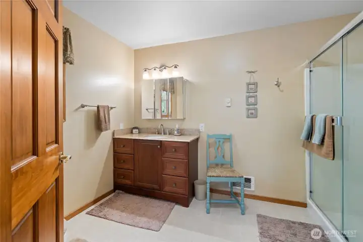 Clean and well-maintained full bath with natural wood cabinetry.