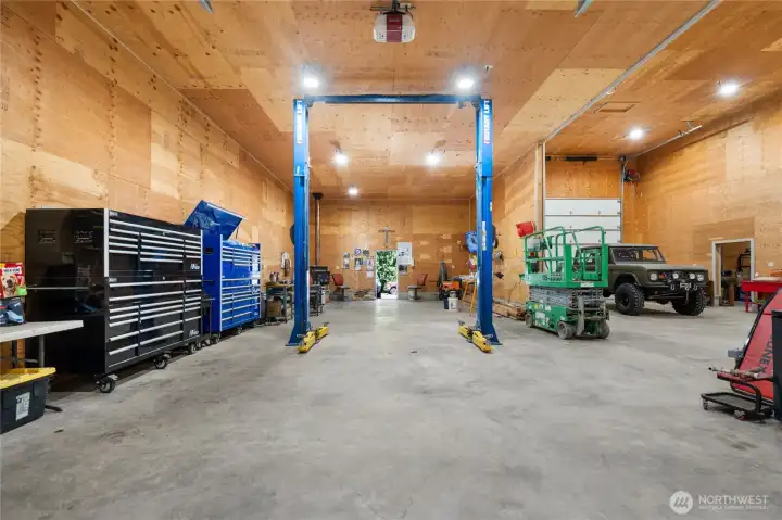 Fully functional workspace with custom shelving, high ceilings, and industrial lighting.