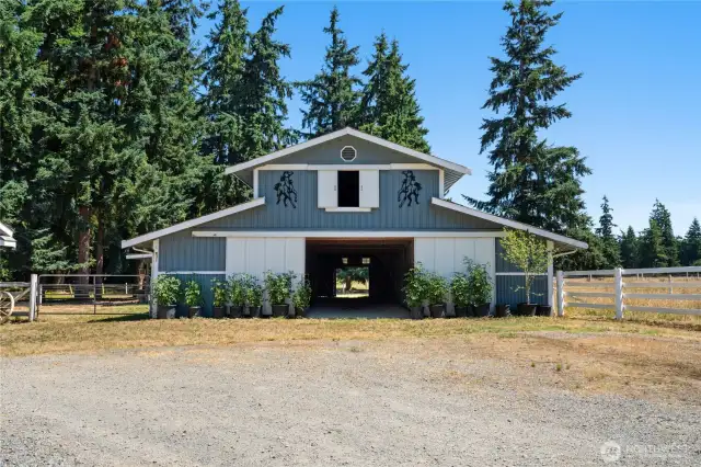 Exceptional equestrian facility featuring 13 total stalls: nine 12x12 stalls and two oversized 14x6 stalls (which can be divided). Each stall includes a dedicated water source. The barn also offers a built-in wash rack, 10 feeding stalls, and spacious hay storage above in the loft.