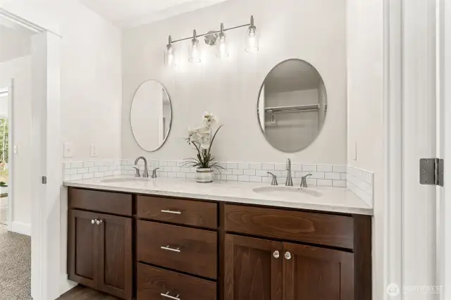 Primary bath with double vanity, custom cabinetry with separate walk-in closet.