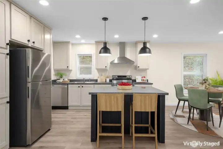 Virtually staged kitchen with eat-in island, dining space to the right, and living space behind