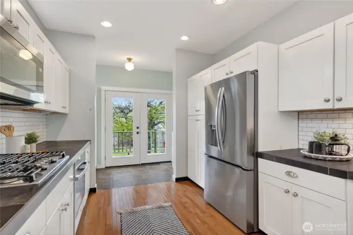 Kitchen is connected through french doors and leads onto outdoor deck.