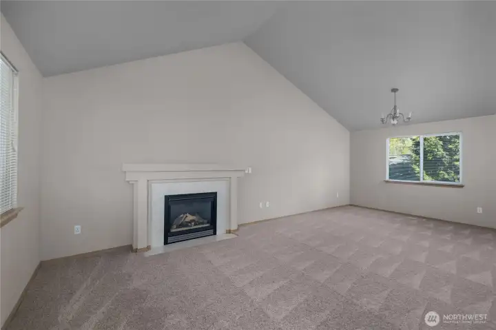 Cozy living room with gas fireplace and room for dining area, also featured a vaulted ceiling for better natural light. Brand new carpet throughout home!