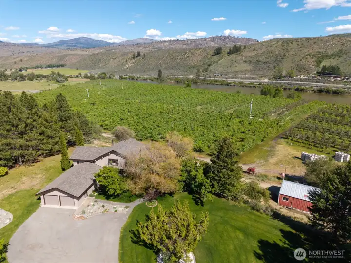 Aerial showing home, organic pear orchard below (neighboring property) and shop