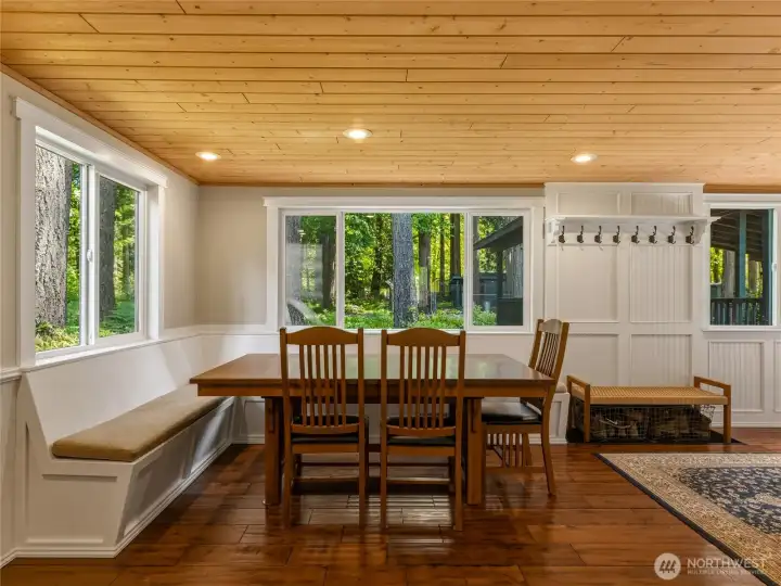 Dining area with custom built-in seating and coat rack near the front door