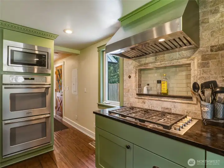 6 burner propane gas stove, stainless hood vent and custom travertine backsplash w/ glass tile nook