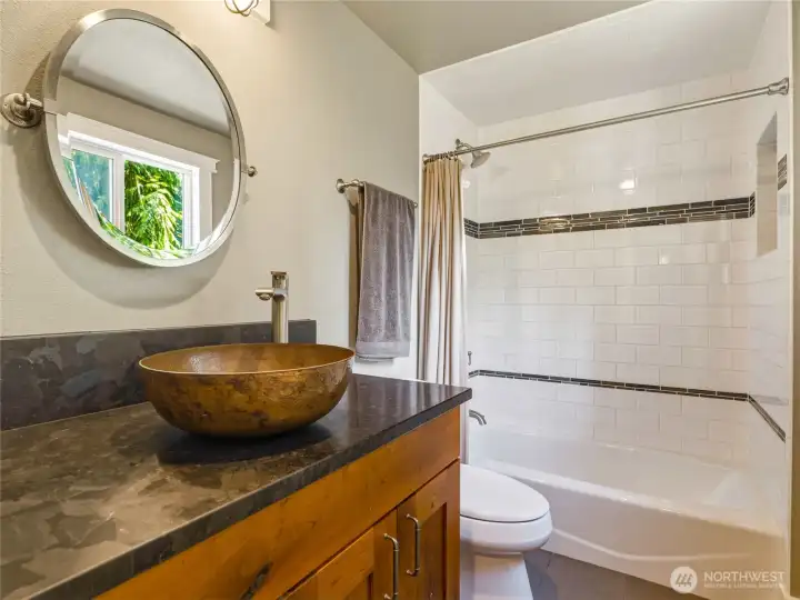 downstairs full bathroom with porcelain tile floors and shower, solid cherry cabinet, granite countertop and copper sink