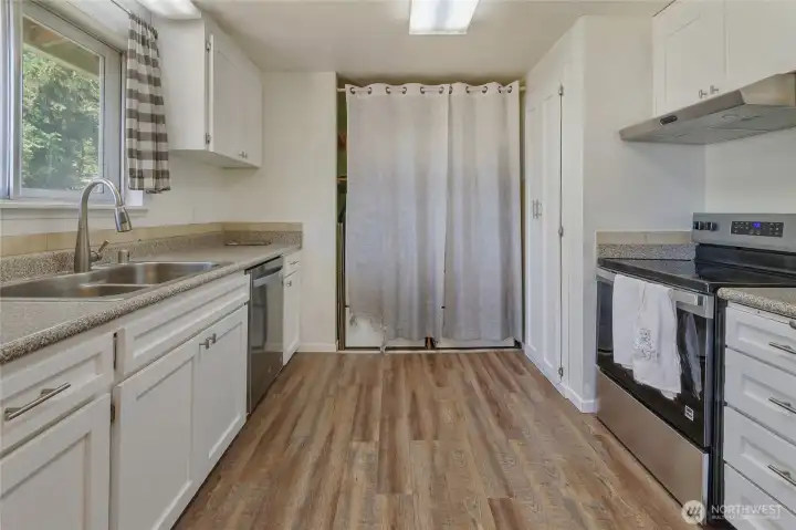 Kitchen looking to laundry area behind curtain