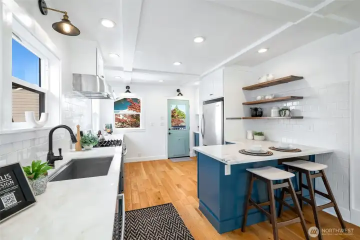 There is a large island with room for eat-in/breakfast bar space. The door goes out to the back deck and yard and there is even more counter and pull out pantry on the other side of the refrigerator.