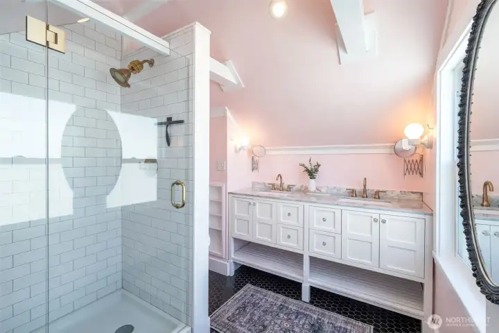 The upstairs bathroom had a custom glass door added to it, such a nice upgrade. A large double sink vanity with quartz countertops and built-in storage- and great light coming from the north.