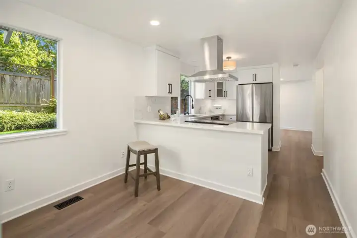 Bright and cheerful dining space and a peninsula island that creates additional workspace.