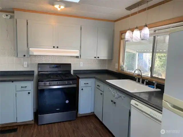 The kitchen features lots of cabinet and counter space, new gas range and more!