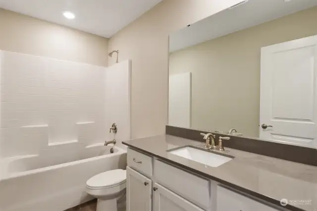Primary bathroom featuring shower & bathtub and spacious sink.