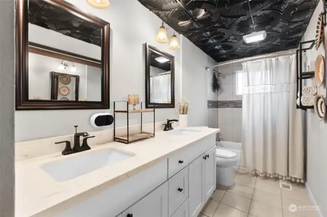 Welcome guests to a luxurious full bathroom featuring double sinks! Enjoy the convenience of an extra-long vanity offering ample counter space & storage for all your toiletries.