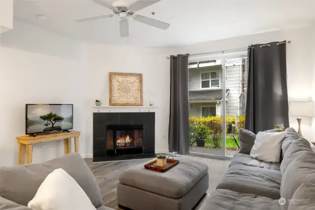 Spacious living area with wood burning fireplace and celling fan.