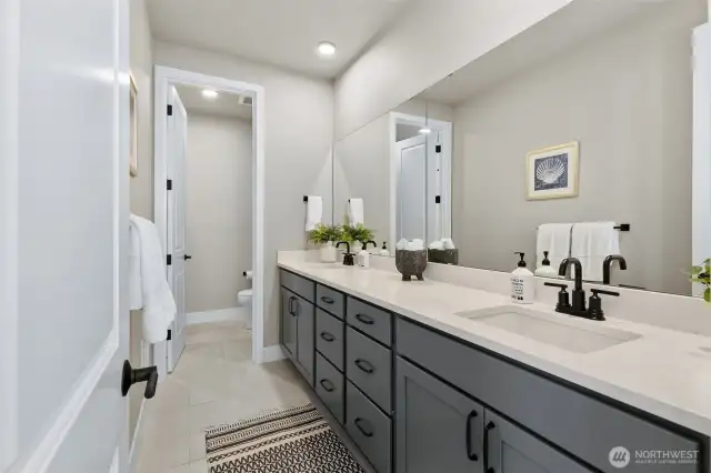 Guest bathroom with dual sinks, separate toilet and tub/shower