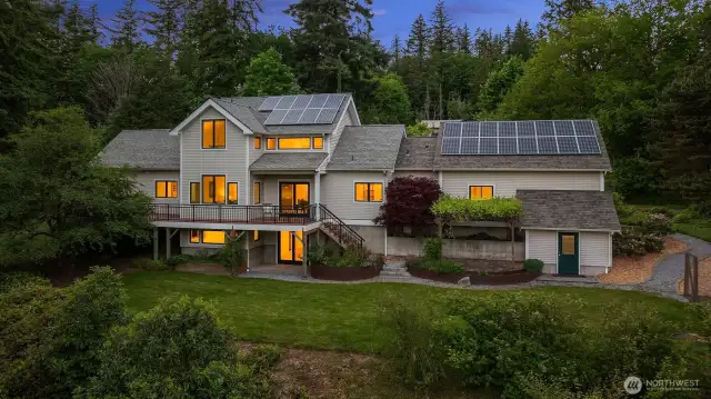 Welcome to 4714 Willis Street, where thoughtful architecture, natural beauty, and sustainable living come together in one exceptional property. This stunning south-facing home is perfectly positioned to capture sunlight and forest views from every angle. Expansive windows, an elevated deck, and a rooftop solar array reflect both intentional design and environmental awareness. Surrounded by mature trees, curated landscaping, and a peaceful greenbelt backdrop, the setting feels like a private retreat—yet you're just minutes from trails, Lake Padden, and everything Bellingham has to offer.