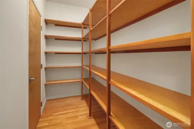Just off the kitchen, this spacious walk-in pantry offers exceptional storage with custom-built shelving from floor to ceiling. Whether you're stocking up on staples, organizing cookware, or housing small appliances, there's plenty of room to keep everything tidy and accessible. The hardwood flooring continues into the space, adding warmth and cohesion with the rest of the home. It’s a functional and well-designed feature that supports both everyday living and effortless entertaining.